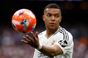 mbappé con un pallone in mano in campo